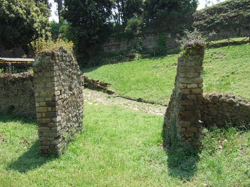Porta Nola tombs plan NGOF Pompeii. May 2006. View from gateway in tufa wall north-west of tomb looking towards the city walls near the Nola Gate. 
According to De Caro, “The group of people found in the recent explorations was composed of 15 individuals, all of whom fell in the space of a few metres”. 
See De Caro S., 1976. Scavi nell’area fuori Porta Nola a Pompei: Cronache Pompeiane V, (p.95-101). 
The bodies were found in front of the gateway and down to and on the tufa block road. 
A beaten earth road ran through the gateway and joined the tufa block road.